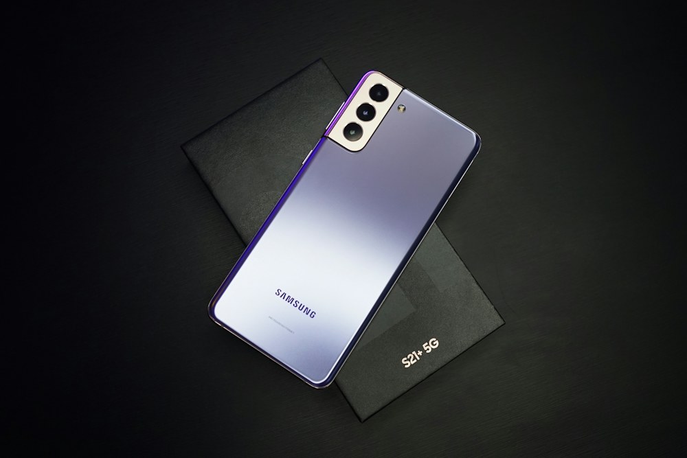 Teléfono Samsung Galaxy junto a su caja sobre un fondo negro