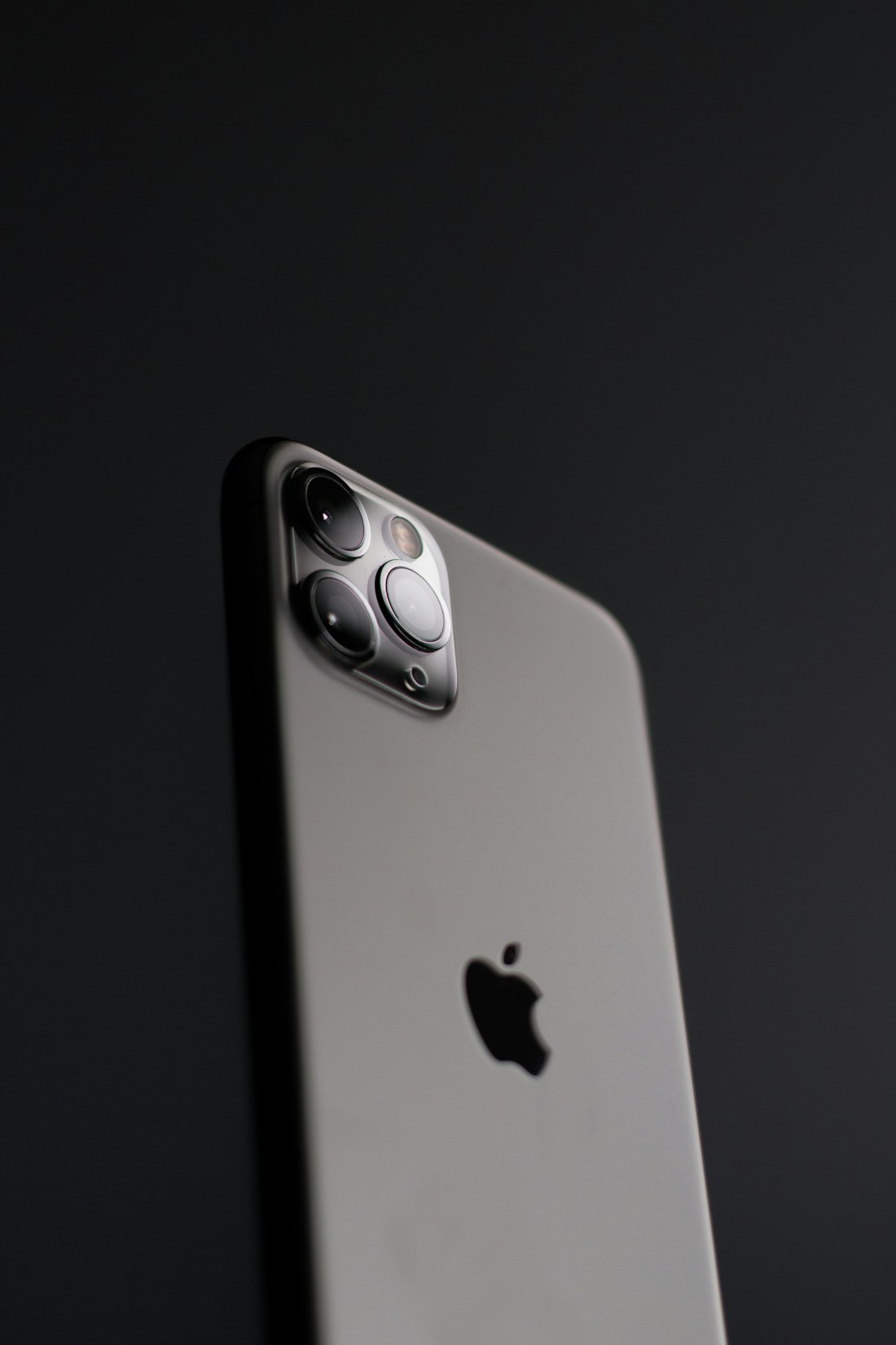 Teléfono iPhone visto por detrás sobre un fondo negro
